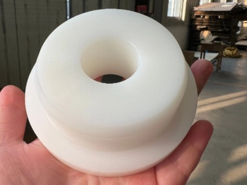 UHMWPE block with machining marks beside polished HDPE part