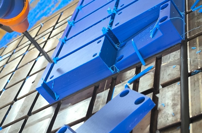 CNC machining UHMW block with visible tool and plastic shavings